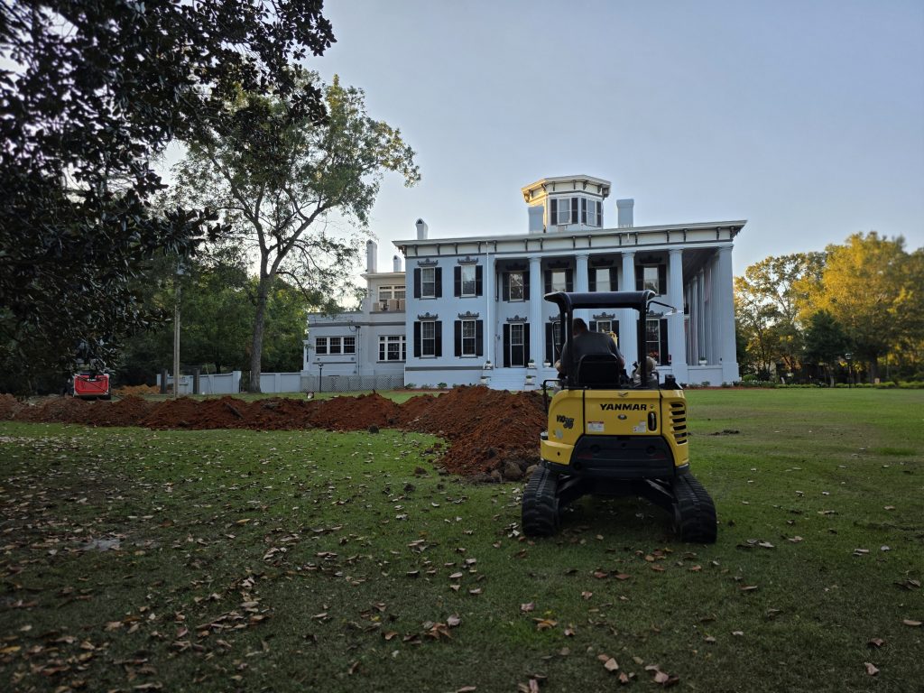 work equipment digging a trench for plumbing